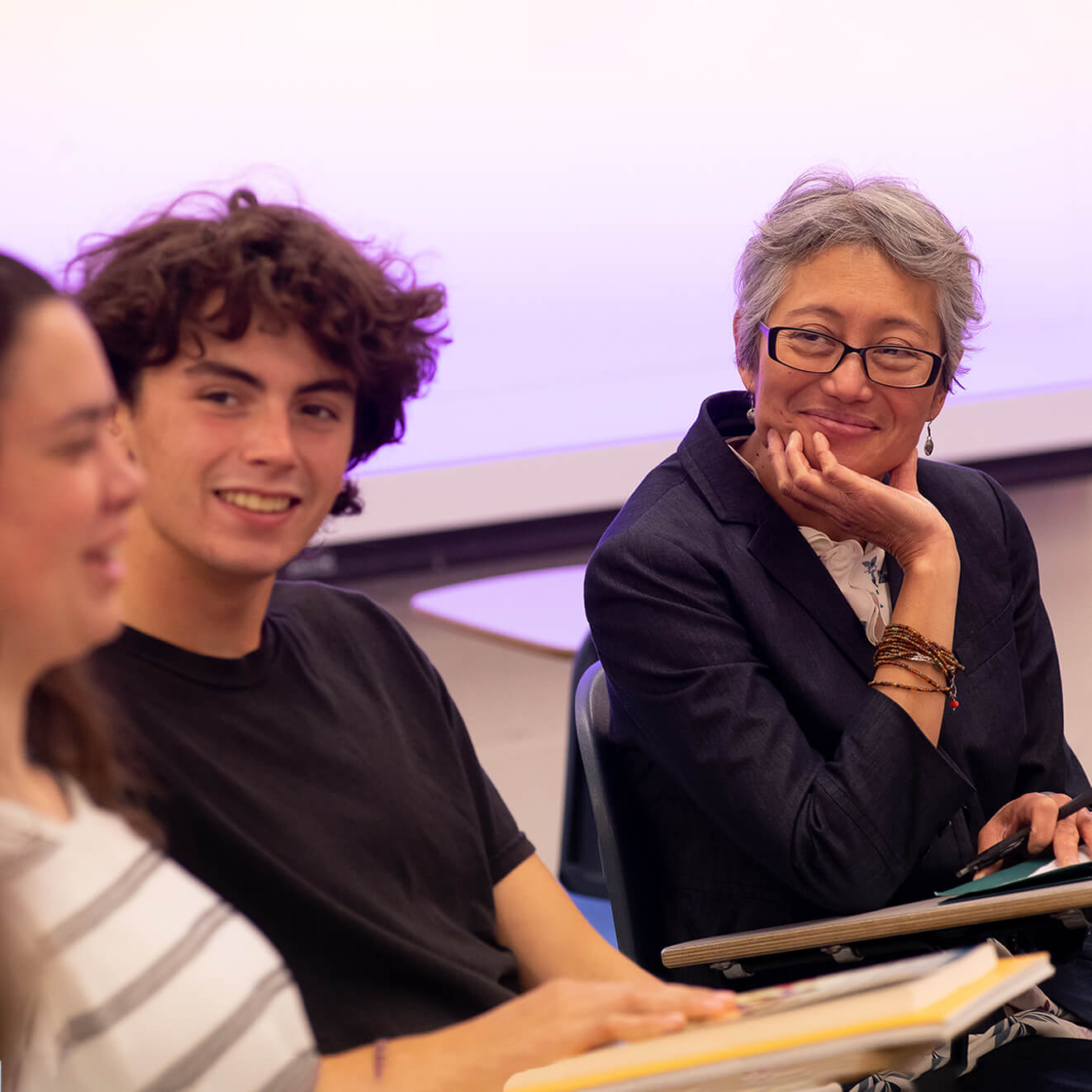 A female faculty member smiles at her students.