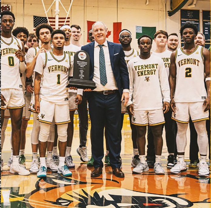 UVM men's basketball team poses with America East trophy