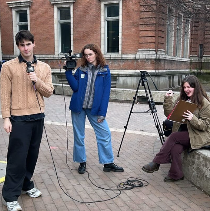 Student journalists pose outside a voting location