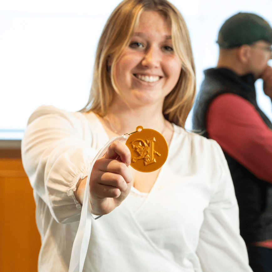 Pippa Scott holds her 3-D printed medal up to the camera