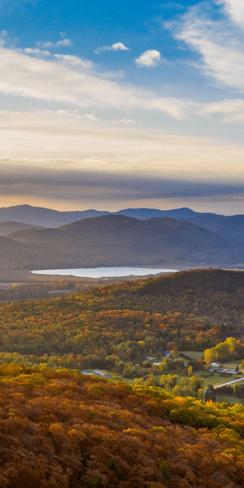 An aerial view of the lake and mountains during peak foliage season.