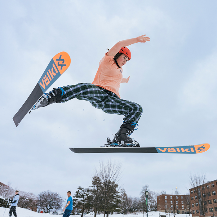 Student on skis performs an aerial maneuver.